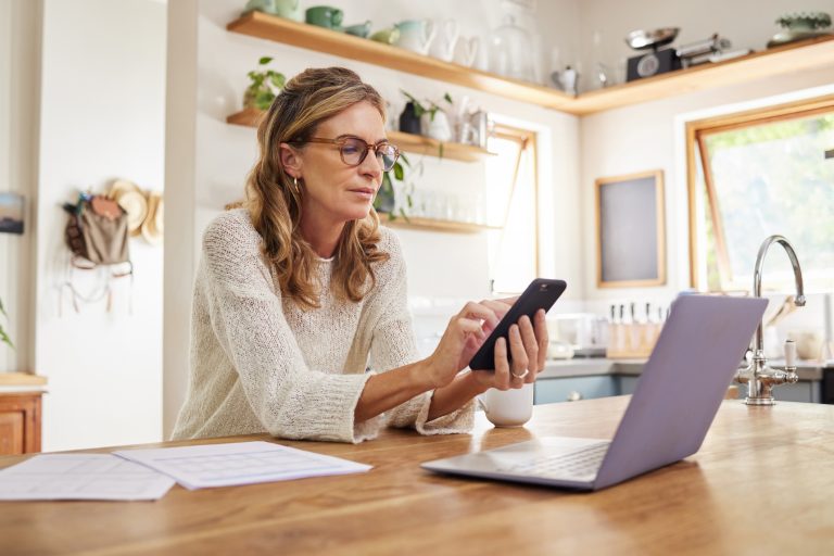 Mature Woman Calls A Non-Profit Debt Management Program On A Smartphone