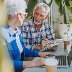 Mature adults reviewing their retirement finances on a laptop