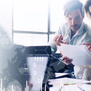 Photograph of a couple looking at their finances with an overlay of graphs and charts