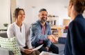 Multiethnic couple handshake with consultant at home