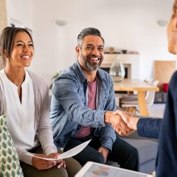 Multiethnic couple handshake with consultant at home